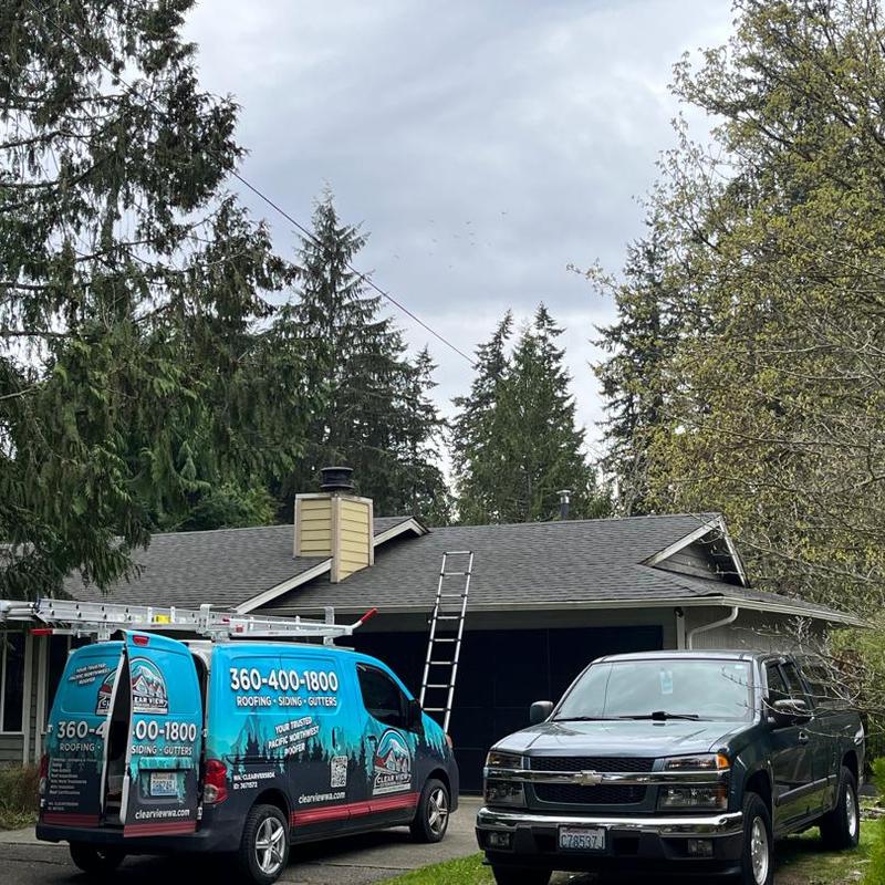 Asphalt shingle roof with ladder and roofing van