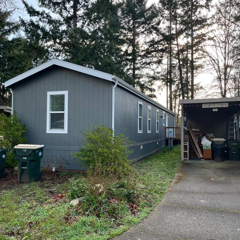 Mobile home exterior siding and windows with greenery