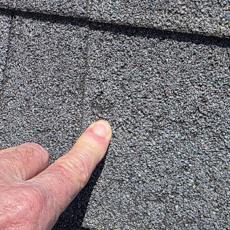 Asphalt roof shingles with hail damage close-up