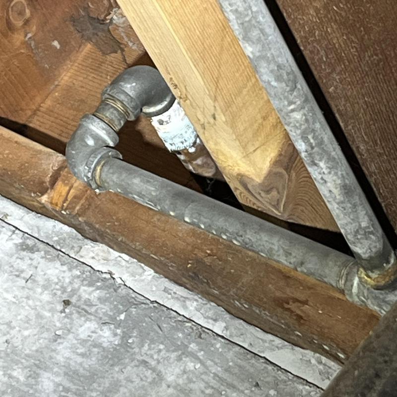 Galvanized steel water pipes in crawl space view