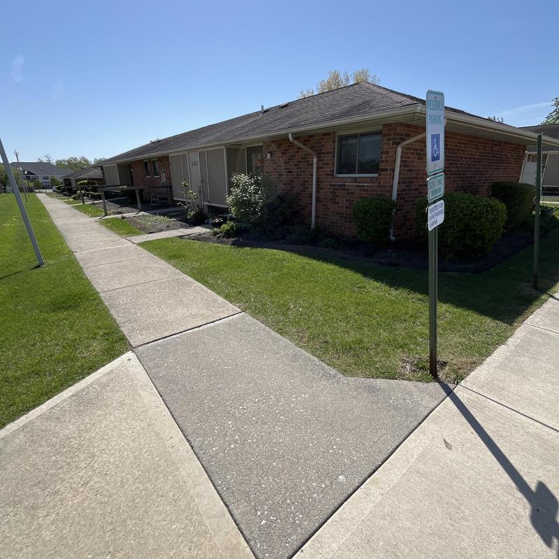 Asphalt shingle roof on brick condos with sidewalks
