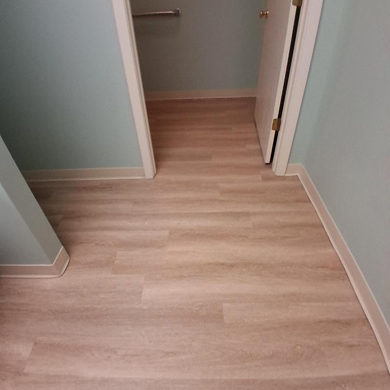 Vinyl plank bathroom flooring with door and baseboards