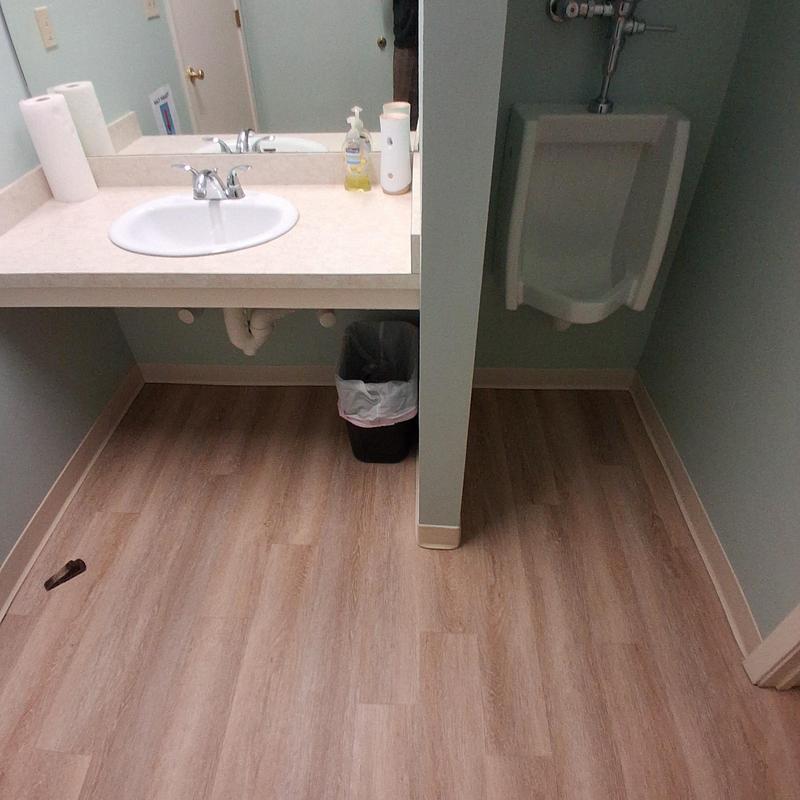 Bathroom sink and urinal with new wood flooring