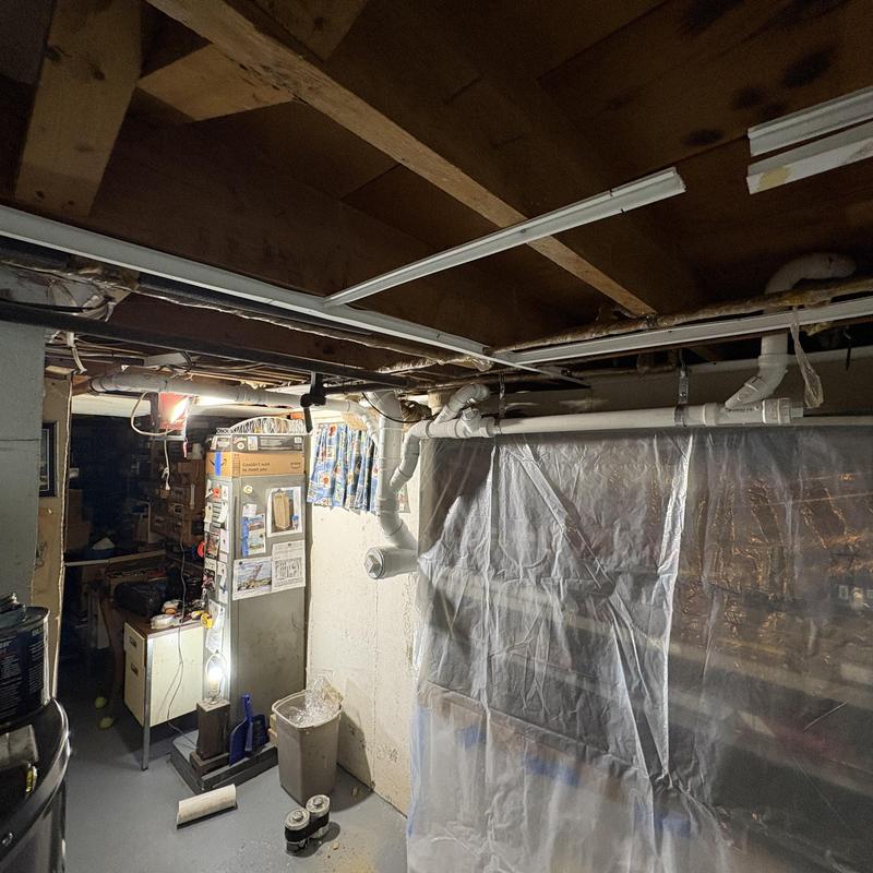 PVC plumbing stack rerouted in basement near dry well