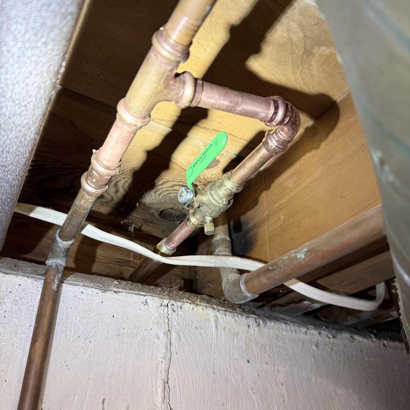 Globe valve with copper pipe connections in basement ceiling