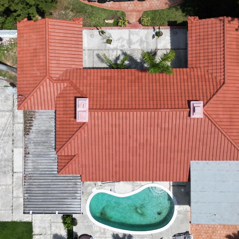 Tile roof with chimneys and backyard pool, aerial view