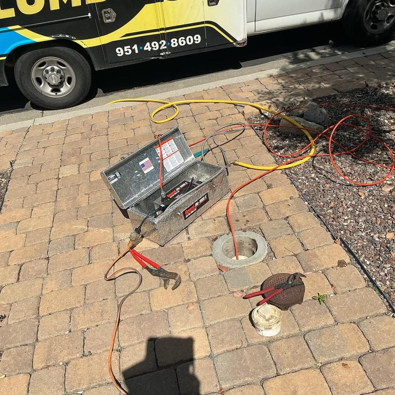 Hydro-Jetter cleaning sewer pipe with tools and van