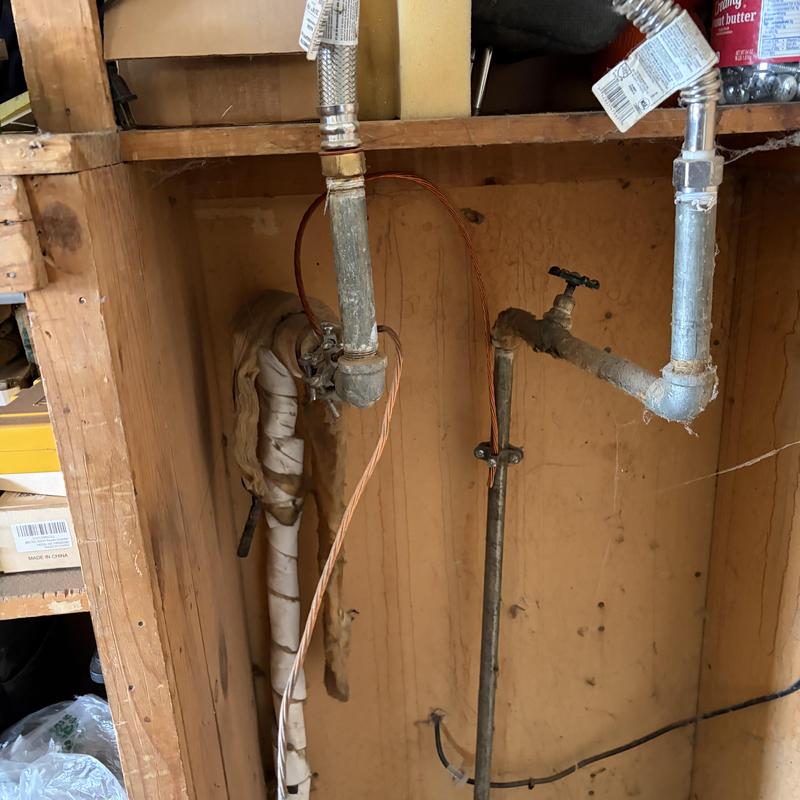 Electric water heater piping and shutoff valve in garage