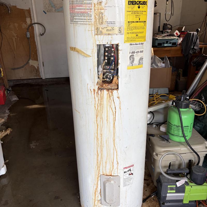 Electric water heater with rust and leakage in garage