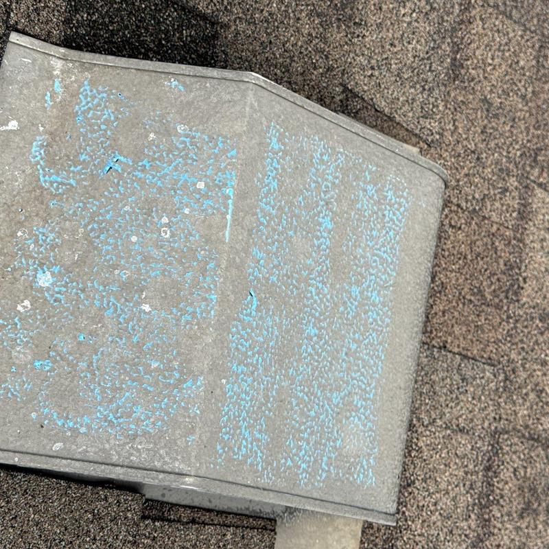 Metal roof vent with hail damage and granule loss