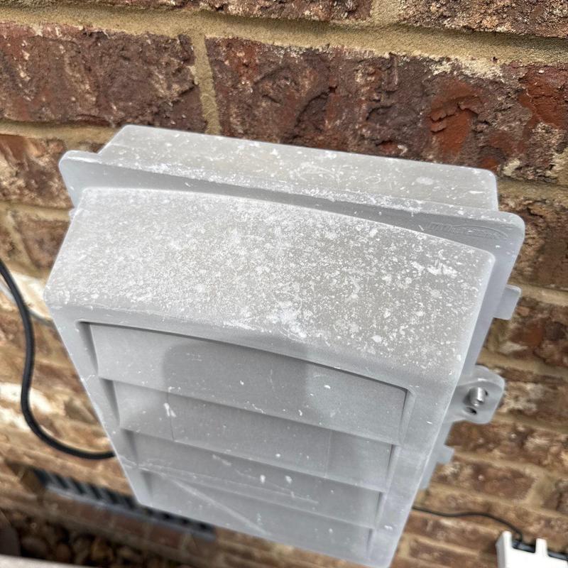 Exterior dryer vent cover with weathering buildup