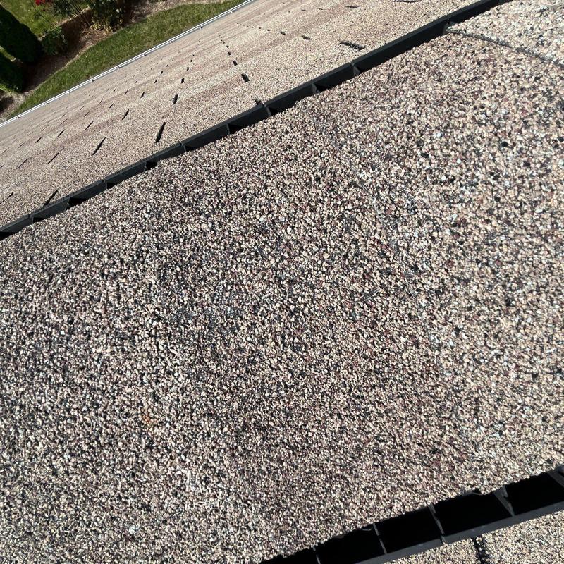 Asphalt shingles with hail damage on roof ridge