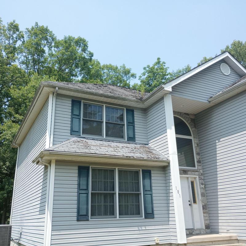 Asphalt shingle roof with visible wear and damage Asphalt shingle roof with visible wear and damage