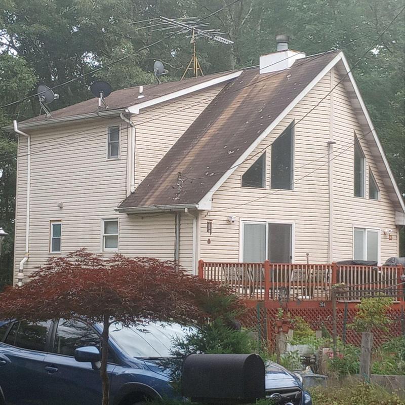 Asphalt shingle roof with visible wear and damage Asphalt shingle roof with visible wear and damage
