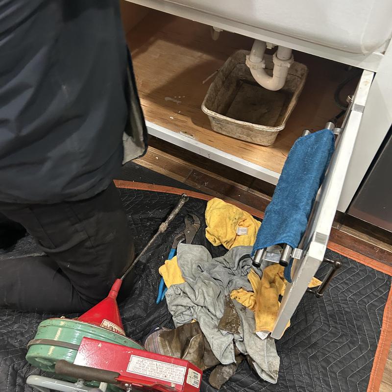 Kitchen sink drain line with plumbing tools and rack