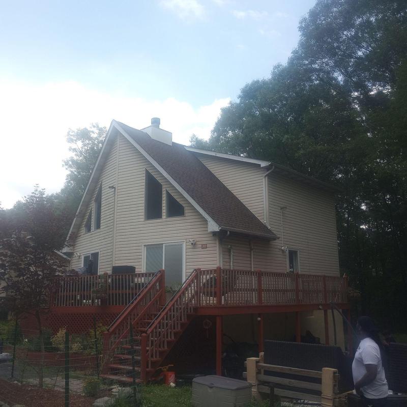 Asphalt shingle roof on tan home with deck stairs Asphalt shingle roof on tan home with deck stairs