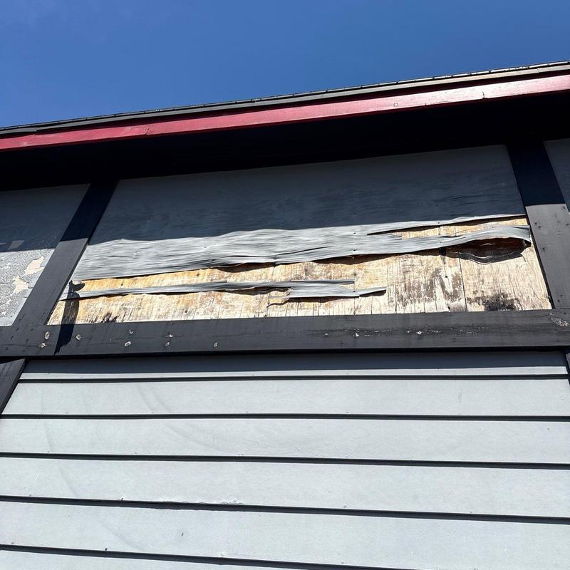 Siding with warped and damaged panels on house exterior