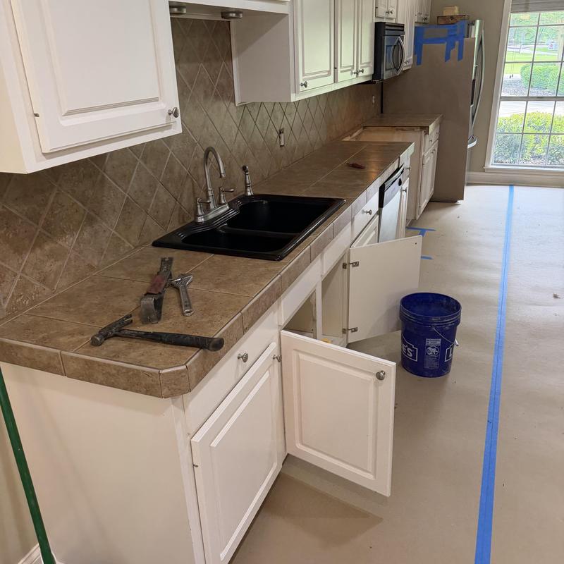 Tiled kitchen countertop and backsplash with open cabinets