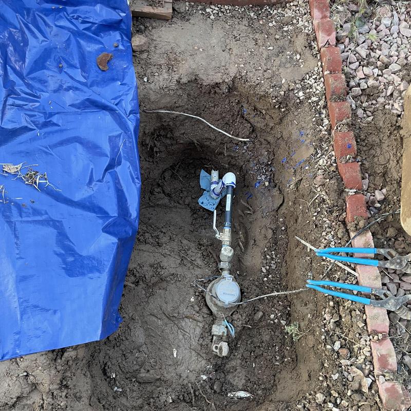 PVC water pipe and brass ball valve installation in trench