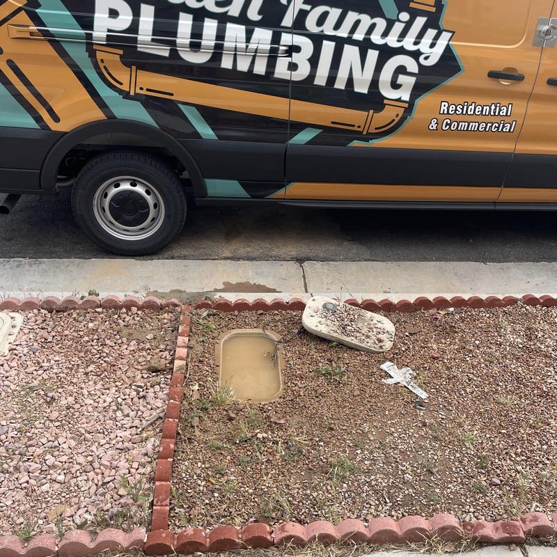 PVC pipe leak excavation near sidewalk with plumbing van