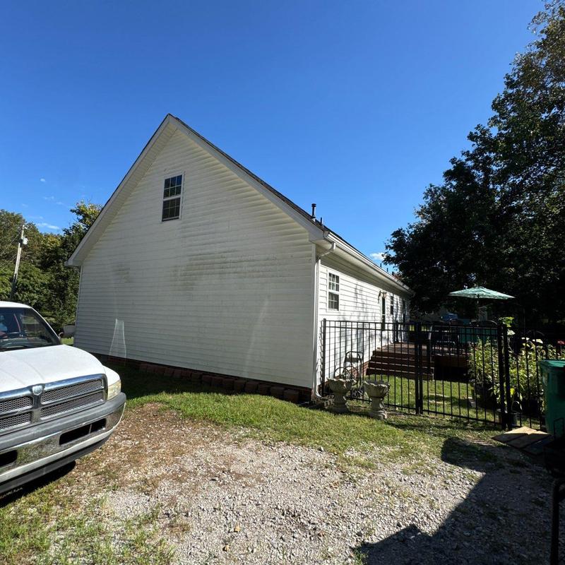 Vinyl siding exterior with dirt stains and driveway view