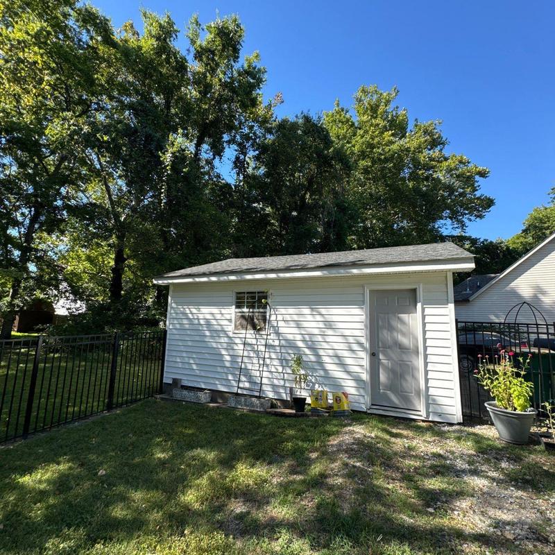 Asphalt shingle roof on backyard shed with nearby plants