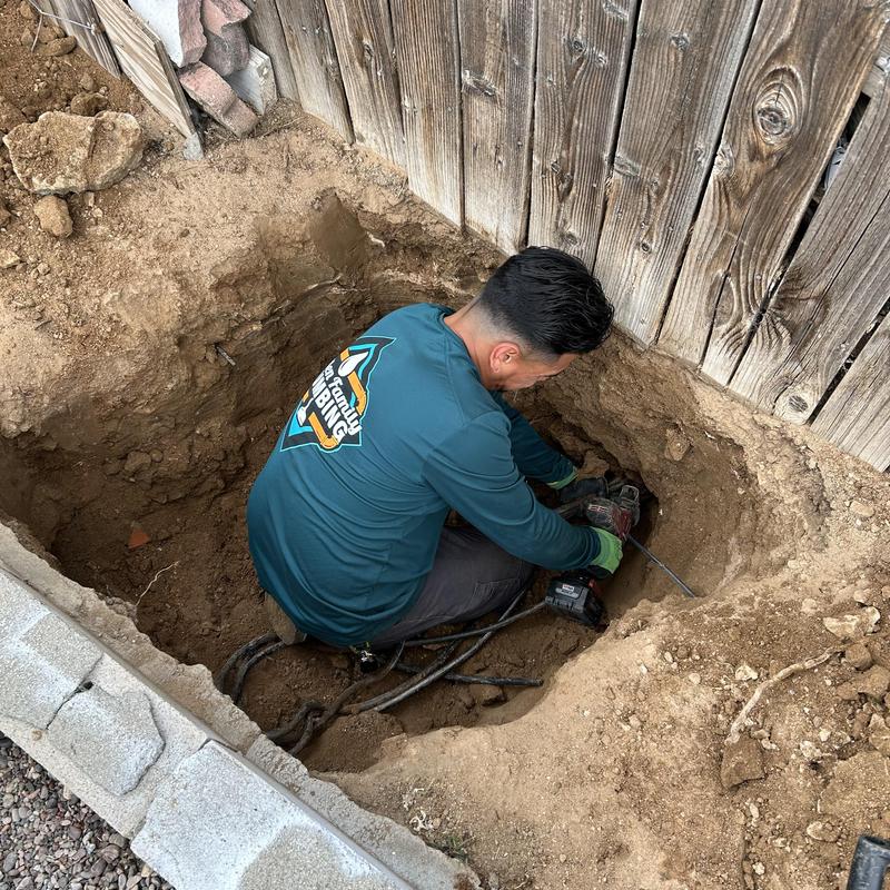 Drain pipe excavation and repair near wooden fence