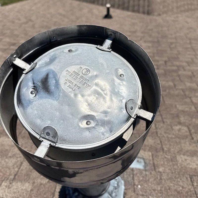 Metal roof vent cap with hail damage dents