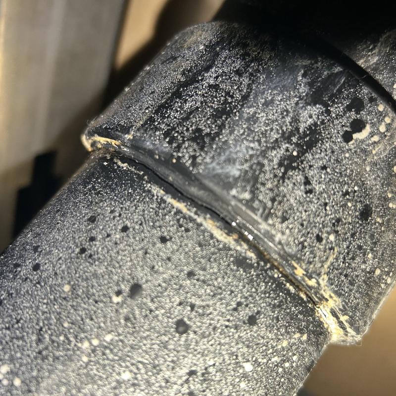 PVC pipe crack close-up with dirt and dust particles
