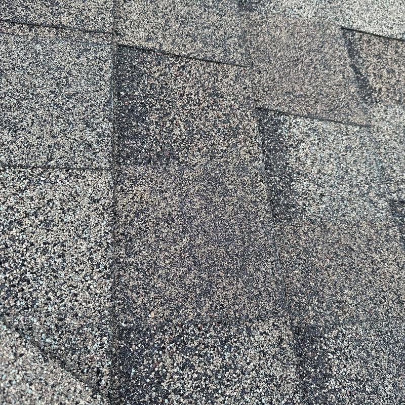 Architectural roof shingles with hail damage close-up