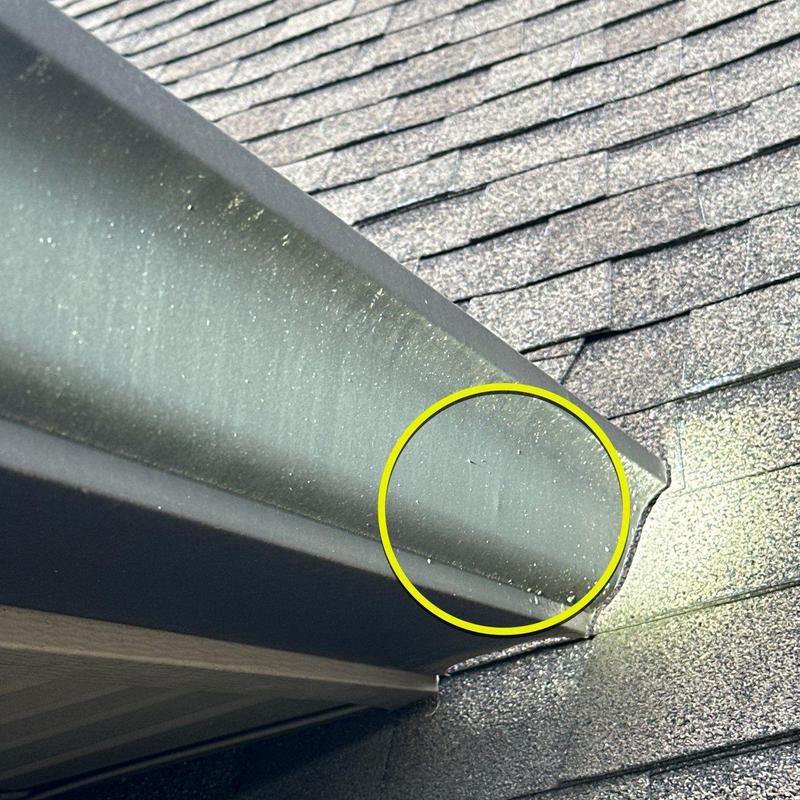 Metal gutter with hail damage on roof edge