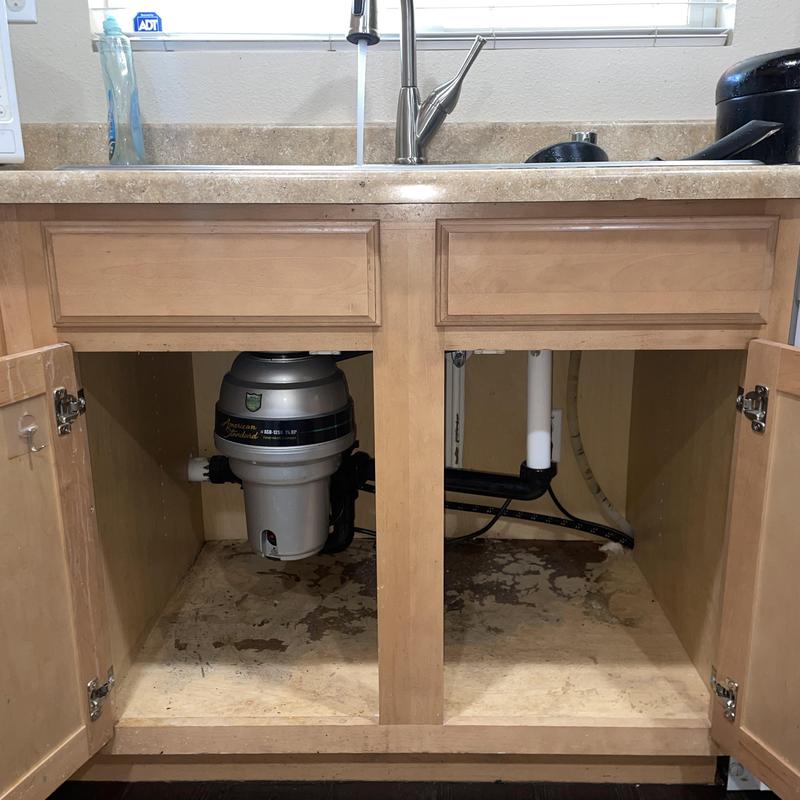 Kitchen sink garbage disposal installed with plumbing