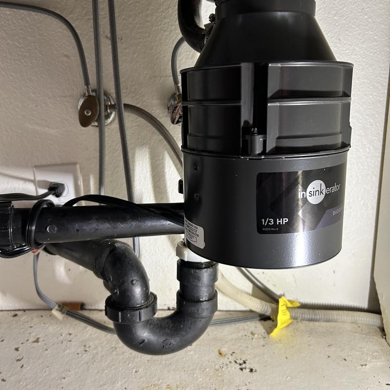 Garbage disposal and drain pipes under kitchen sink