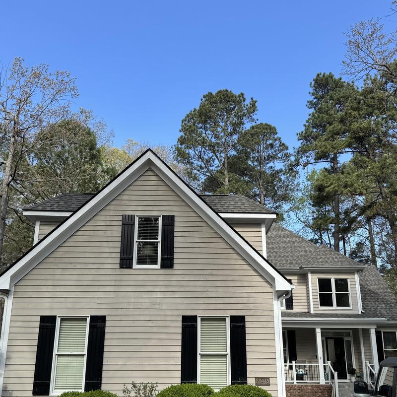Asphalt shingle roof and beige siding on house
