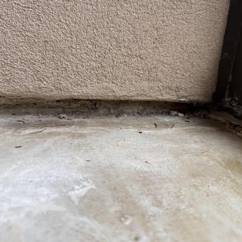 Deck flashing gap with debris buildup and damaged sealant