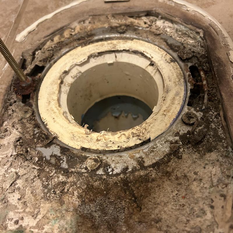 Closet flange with deteriorated bolts and rust damage