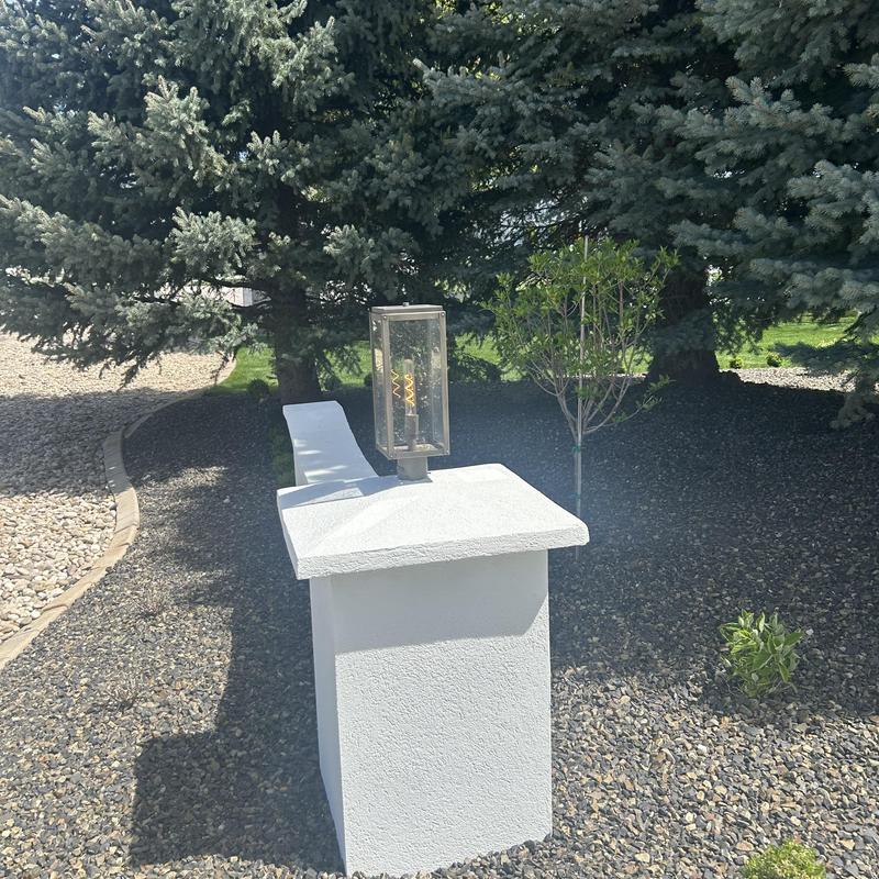 Landscape lighting fixture on white pillar in yard