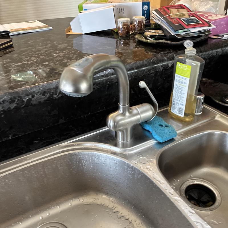 Kitchen faucet and sink installation with sponge nearby