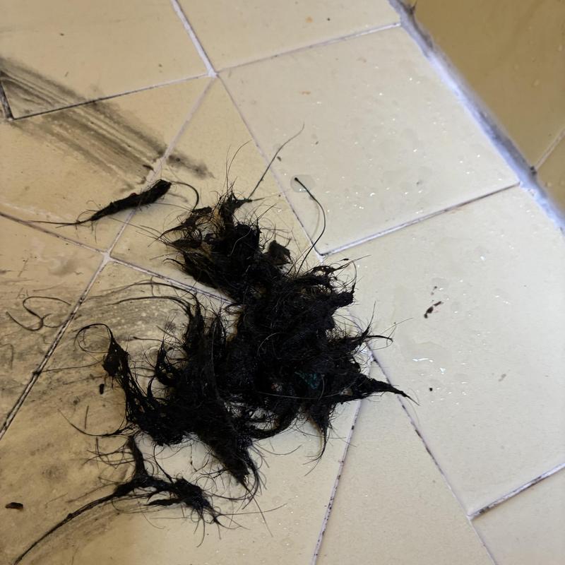 Shower drain hair clog removal on tiled floor