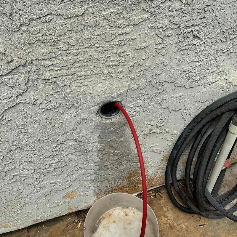 Kitchen drain line with red cleaning hose inserted