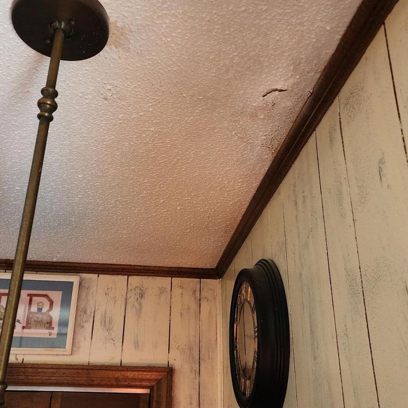 Ceiling water damage near crown molding and wall clock Ceiling water damage near crown molding and wall clock