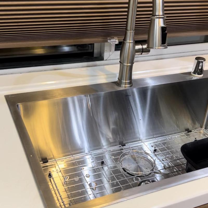 Stainless steel kitchen sink with faucet and grid