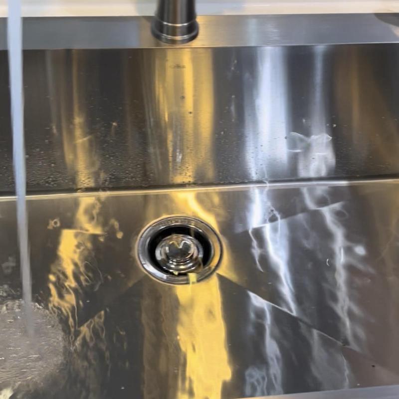 Stainless steel kitchen sink with running water