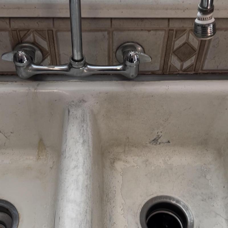 Cast iron sink with wall-mounted faucet and drain holes