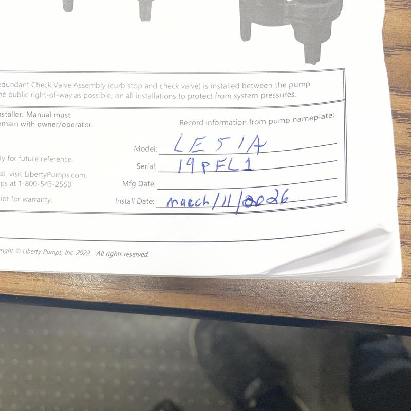 Sump pump installation record form on wooden desk