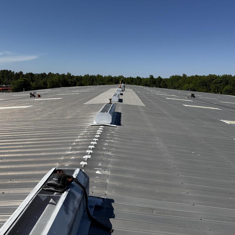 Metal roof ridge cap with sealed fasteners and skylights