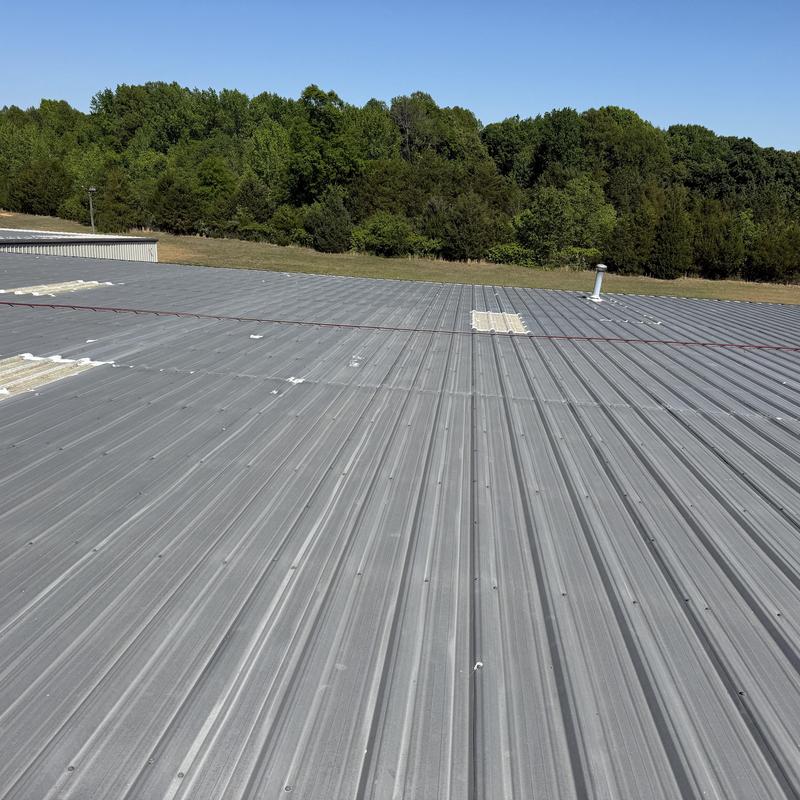 Metal roof with sealed penetrations and coated skylights