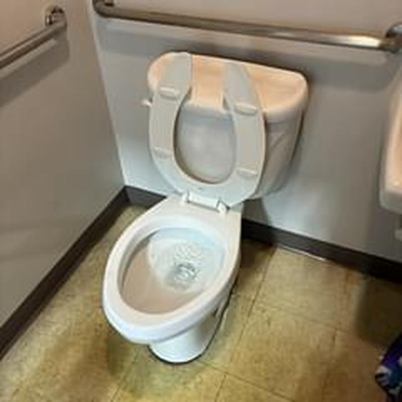 Toilet with open seat in commercial bathroom