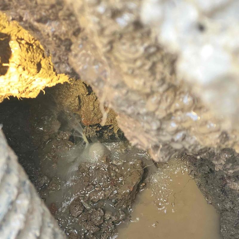 Underground water pipe leak spraying muddy water