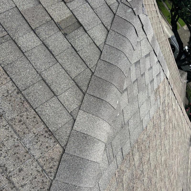 Roof shingles lifting along valley with damage repairs Roof shingles lifting along valley with damage repairs